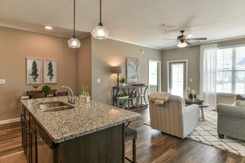 A kitchen with an island and a living room in the background 